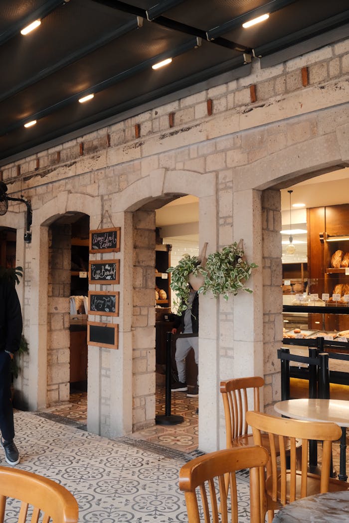 Charming outdoor café with stone arches and wooden furniture, offering a warm and inviting atmosphere.