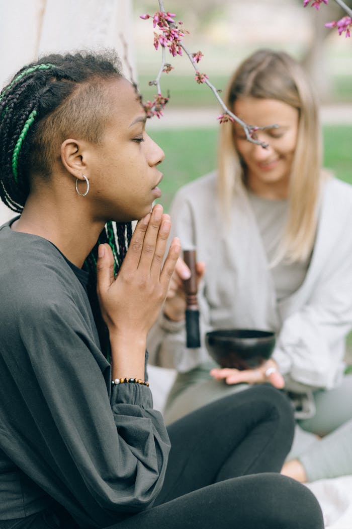 who-we-are Two women meditating peacefully outdoors, engaged in a mindful practice.